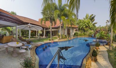 Relaxing Villa with palm trees beside pool 