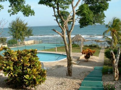 Below the house: Pool, thatch hut, sea